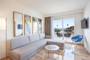 a living room with a couch and a table at Grupotel Los Príncipes & Spa in Playa de Muro
