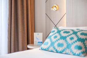 a room with a bed with a pillow and a window at Grupotel Los Príncipes & Spa in Playa de Muro