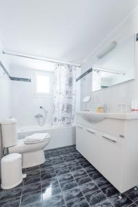 a white bathroom with a toilet and a sink at Villa Arokaria in Stení +18 photos