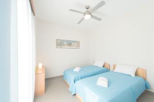 two beds in a room with a ceiling fan at Villa Arokaria in Stení