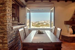a dining room with a wooden table and a large window at Villa Arokaria in Stení