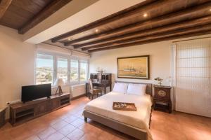 a bedroom with a bed and a flat screen tv at Villa Arokaria in Stení