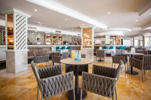 a restaurant with tables and chairs and a bar at Grupotel Los Príncipes & Spa in Playa de Muro