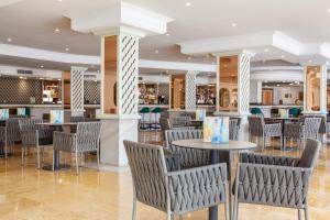 a restaurant with tables and chairs and a bar at Grupotel Los Príncipes & Spa in Playa de Muro