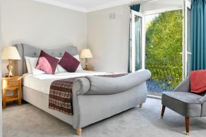 a bedroom with a bed and a chair and a window at Mount Wolseley Hotel Spa & Golf Resort in Tullow