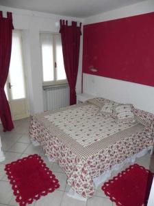 1 dormitorio con 1 cama con paredes y ventanas de color rojo en La Locanda Al Lago, en Verbania