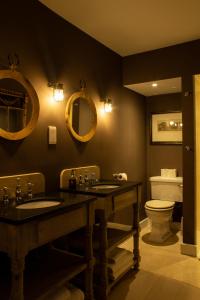 a bathroom with two sinks and a toilet at The Carden Arms in Tilston +41 photos
