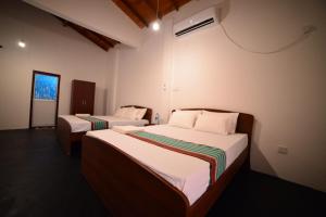Habitación con 2 camas en una habitación en Tamarind Blue, en Tangalle
