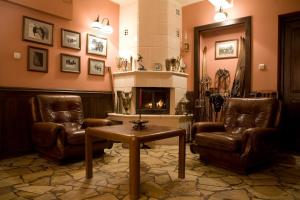 a living room with two chairs and a fireplace at Szarotka in Zakopane