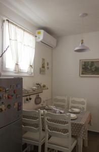 uma cozinha com uma mesa e cadeiras e um frigorífico em Apartman Sofija em Zadar