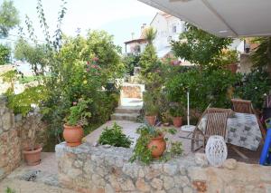 a patio with chairs and potted plants and trees at Marilia Home in Kounoupidhianá