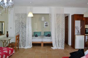 a bedroom with a bed with curtains and a table at Marilia Home in Kounoupidhianá +5 photos