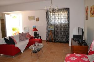 a living room with a red couch and a table at Marilia Home in Kounoupidhianá