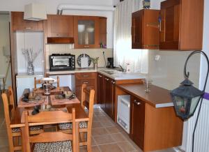 a kitchen with a wooden table and a small table and chairs at Marilia Home in Kounoupidhianá