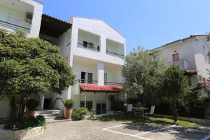 an apartment building with a parking lot and trees at Elia in Skála Foúrkas