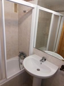 a bathroom with a sink and a shower and a tub at Solmar II Solo Familias Serviplaya in Playa de Xeraco