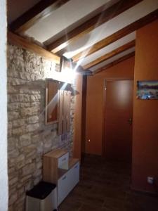 a room with a stone wall and a hallway with a light at APP GAŠI in Buje