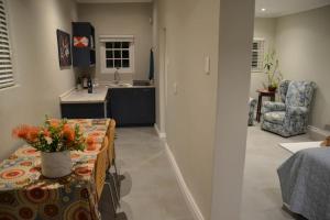 a kitchen and living room with a table with flowers on it at Krom Cottage in Montagu