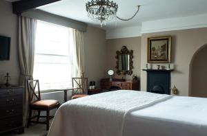 a bedroom with a bed and a table and a chandelier at The Carden Arms in Tilston