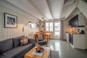 un soggiorno con divano e tavolo di Nyvågar Rorbuhotell - by Classic Norway Hotels a Kabelvåg