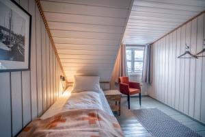 a room with a bed, chair and a window at Nyvågar Rorbuhotell - by Classic Norway Hotels in Kabelvåg