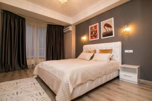 um quarto com uma cama branca num quarto em Rightmove Apartments em Chisinau