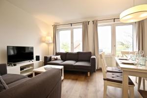 een woonkamer met een bank en een tafel bij Ferienwohnung Leuchtturmblick in Wangerooge