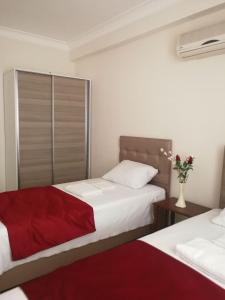 2 Betten in einem Schlafzimmer mit einer roten Decke in der Unterkunft Vacation Apartment Апартаменты в Алании in Mahmutlar