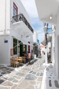 a group of people walking down a street with buildings at Geant Suites Mykonos in Mikonos