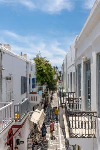 a group of people walking down a street with buildings at Geant Suites Mykonos in Mikonos