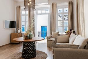 a living room with a couch and a table at Geant Suites Mykonos in Mikonos