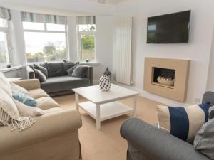 a living room with two couches and a fireplace at Achipur in Porthmadog