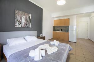 a bedroom with a bed with towels on it at Saffroni Inn in Paralia Katerinis