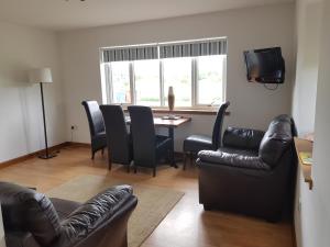 a living room with a couch and a table with chairs at Heathfield Highland Estate in Invergordon