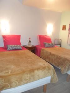 AuthuilleにあるWelcomeの赤い枕が備わる客室内のベッド2台