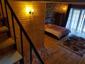 1 dormitorio con 1 cama en una cabaña de madera en Eliya Otel Restoran, en Akarsu