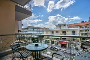 a balcony with a table and chairs and buildings at Saffroni Inn in Paralia Katerinis