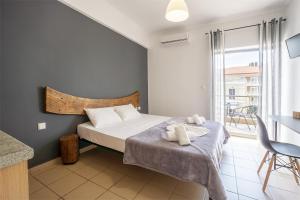 a bedroom with a bed and a large window at Saffroni Inn in Paralia Katerinis