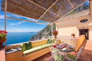 balkon ze stołem i krzesłami oraz oceanem w obiekcie Casa Marina w mieście Positano