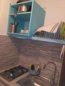 a kitchen counter with a sink and a stove at Appartamento Osnao in Cefalù