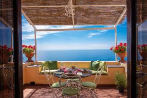 balkon ze stołem i krzesłami oraz oceanem w obiekcie Casa Marina w mieście Positano