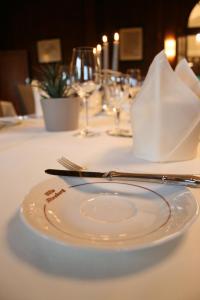 a white plate with a napkin on a table at Hotel Villa Altenburg in Pößneck