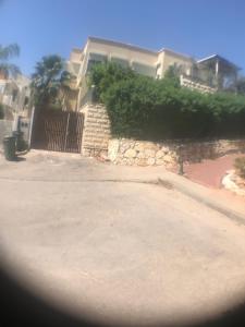 a house with a stone wall and a fence at Magnificant Studio/Zimmer Zichron in Zikhron Ya'akov