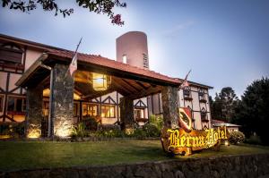 a house with a sign in front of it at Berna Hotel & Spa in Villa General Belgrano