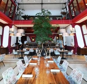 BélestaにあるDomaine Riberach - Restaurant étoilé - Spa - Piscine naturelle - Vignoble bioの大きなダイニングルーム(長いテーブルと椅子付)
