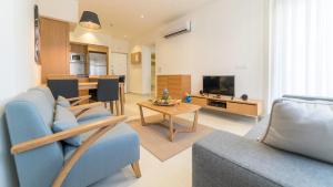 een woonkamer met een blauwe bank en een tafel bij Ramada Resort Kusadasi & Golf in Kuşadası