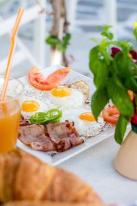 un plato de comida con huevos y carne y una ensalada en Arco Naxos Luxury Apartments, en Naxos Chora