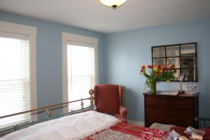 a bedroom with a bed and a chair and a dresser at Sugar Hill Inn in Sugar Hill