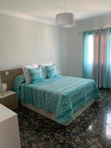 a bedroom with a bed with a blue comforter at Vacacional Tegueste 1ºA in Vecindario