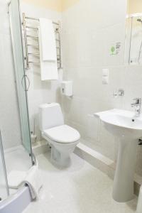 La salle de bains blanche est pourvue de toilettes et d'un lavabo. dans l'établissement Raziotel Kyiv Yamska, à Kiev